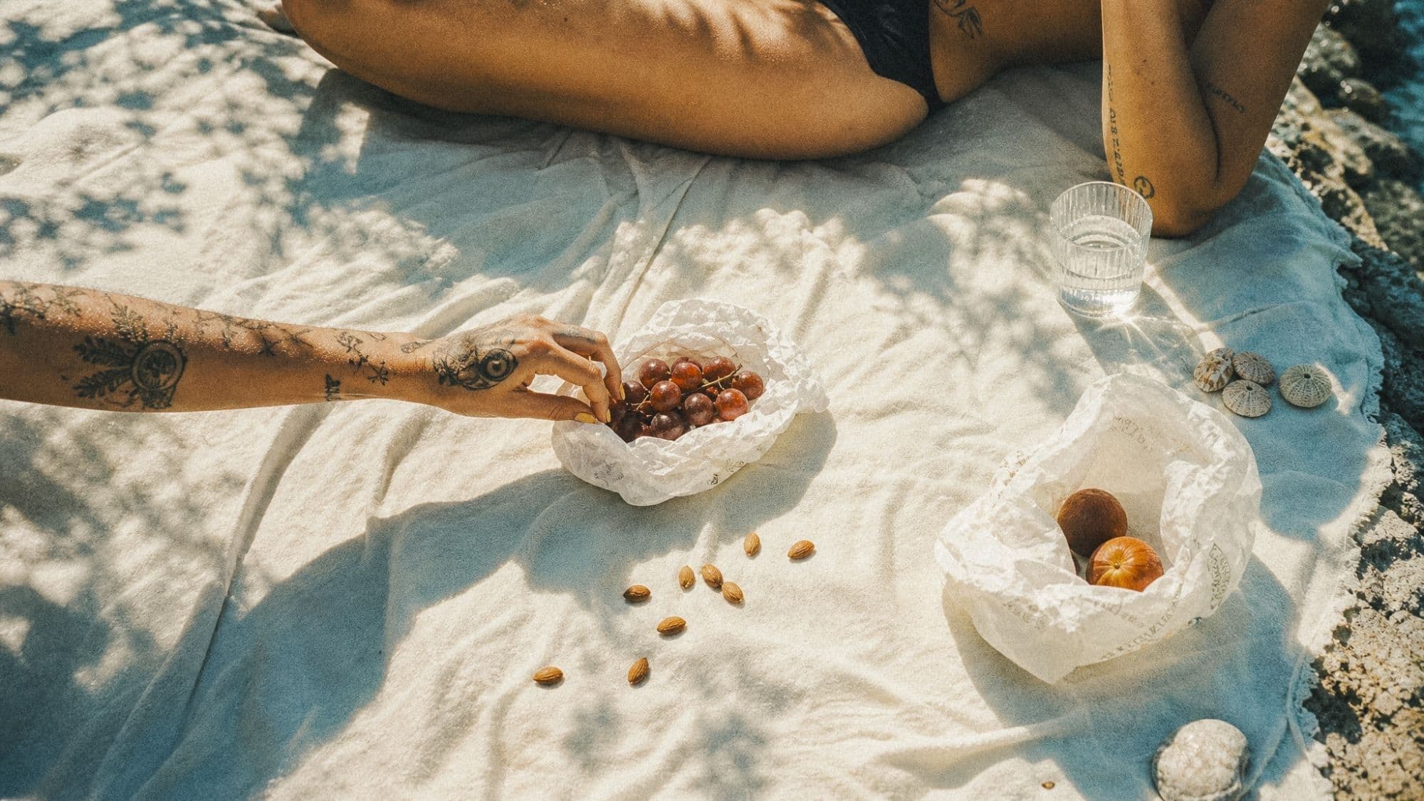 A picnic blanket in the garden with grapes and almonds